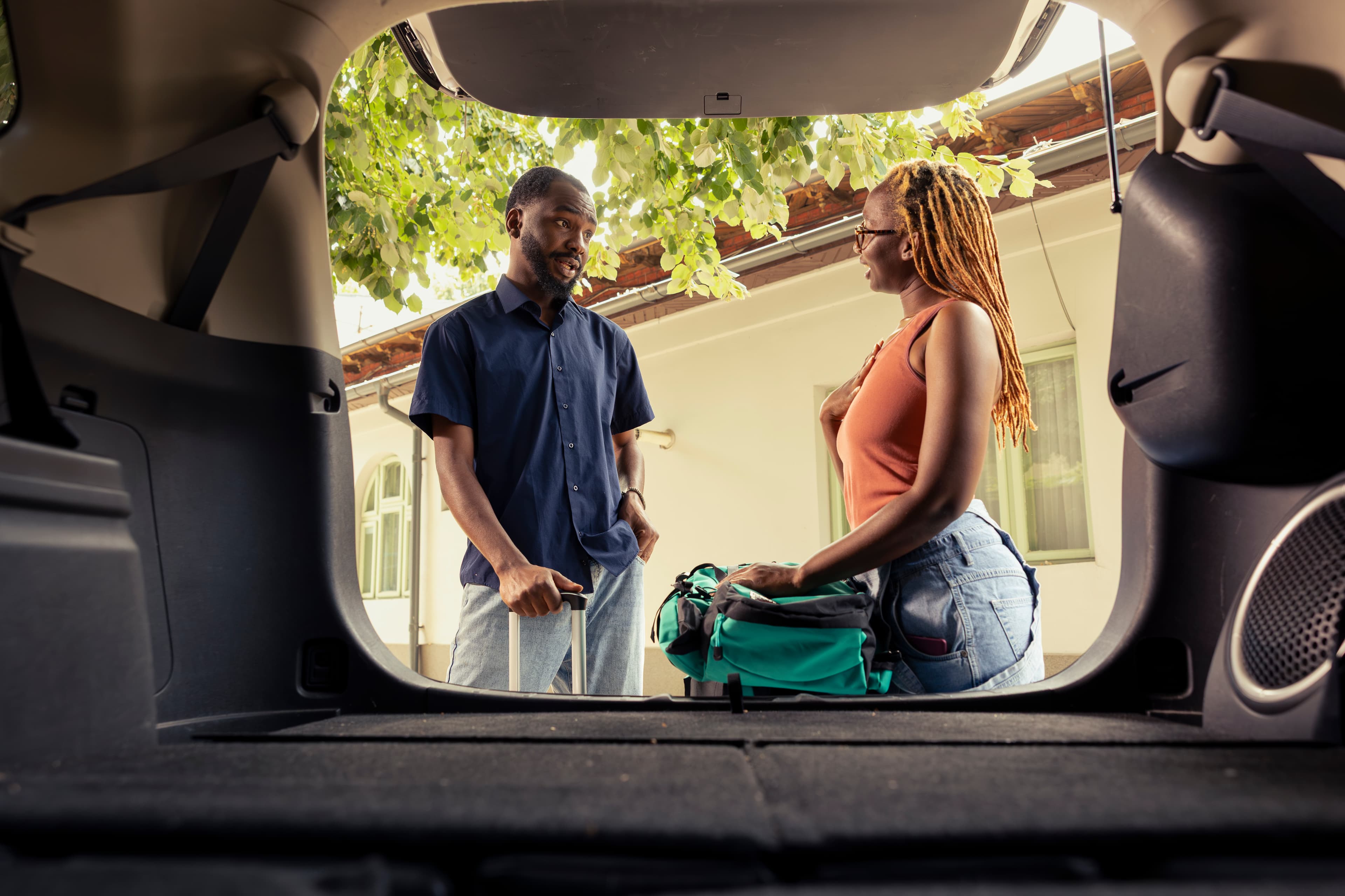 Deux voyageurs organisent leurs bagages avant un trajet en voiture