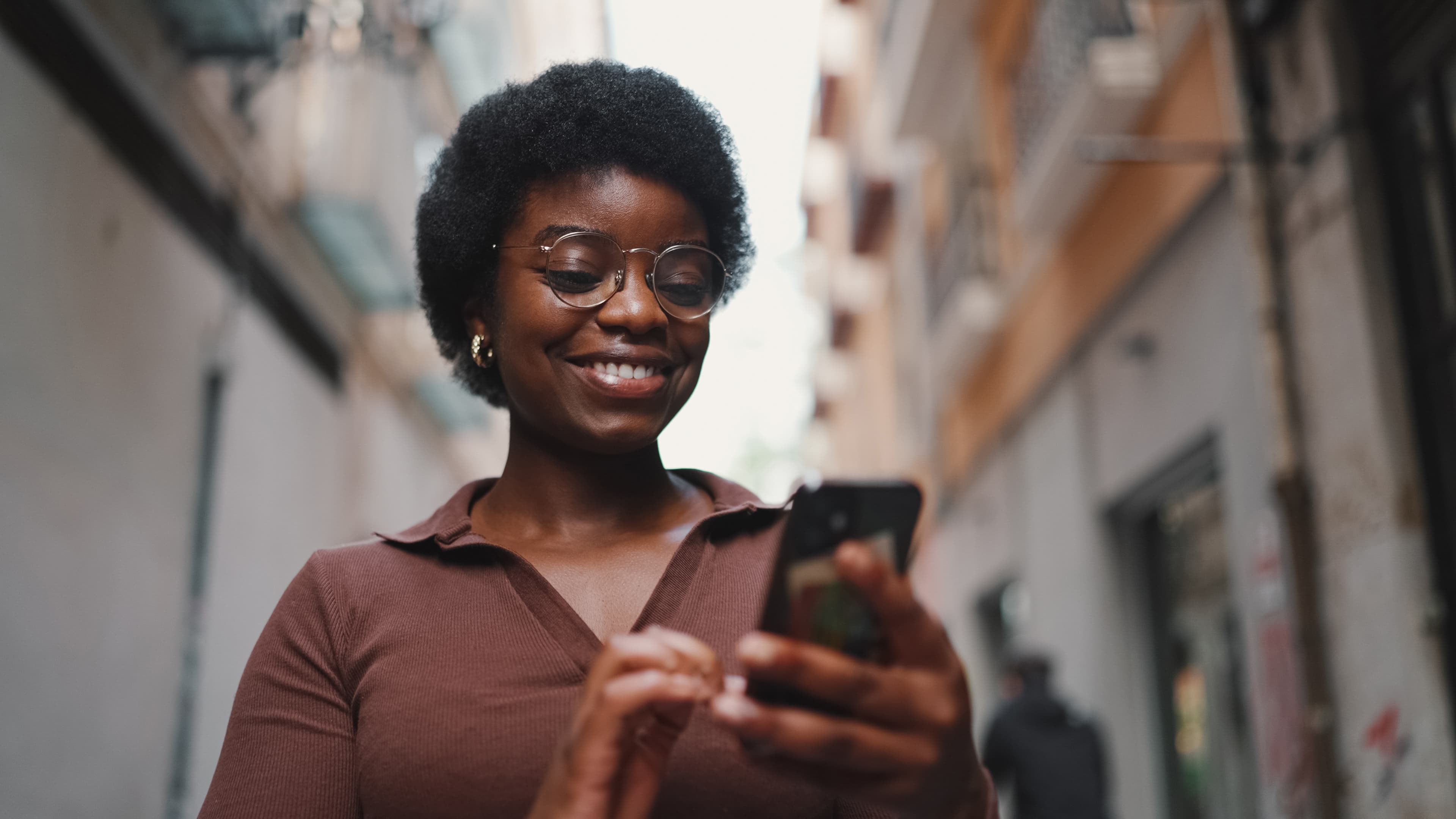 Une utilisatrice consulte l'application sur son téléphone en ville